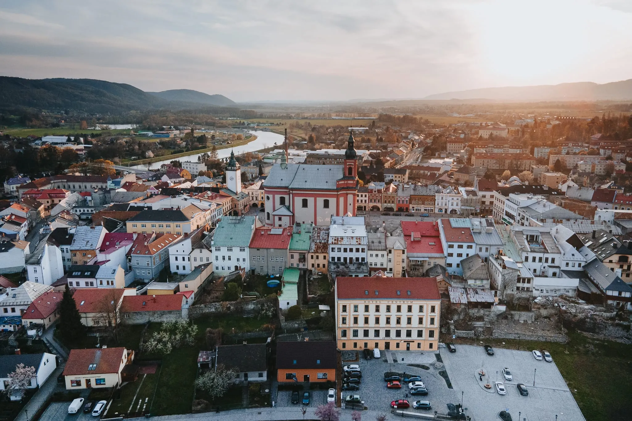 Letecký pohled na Hranice s hotelem Centrum a kostelem při západu slunce