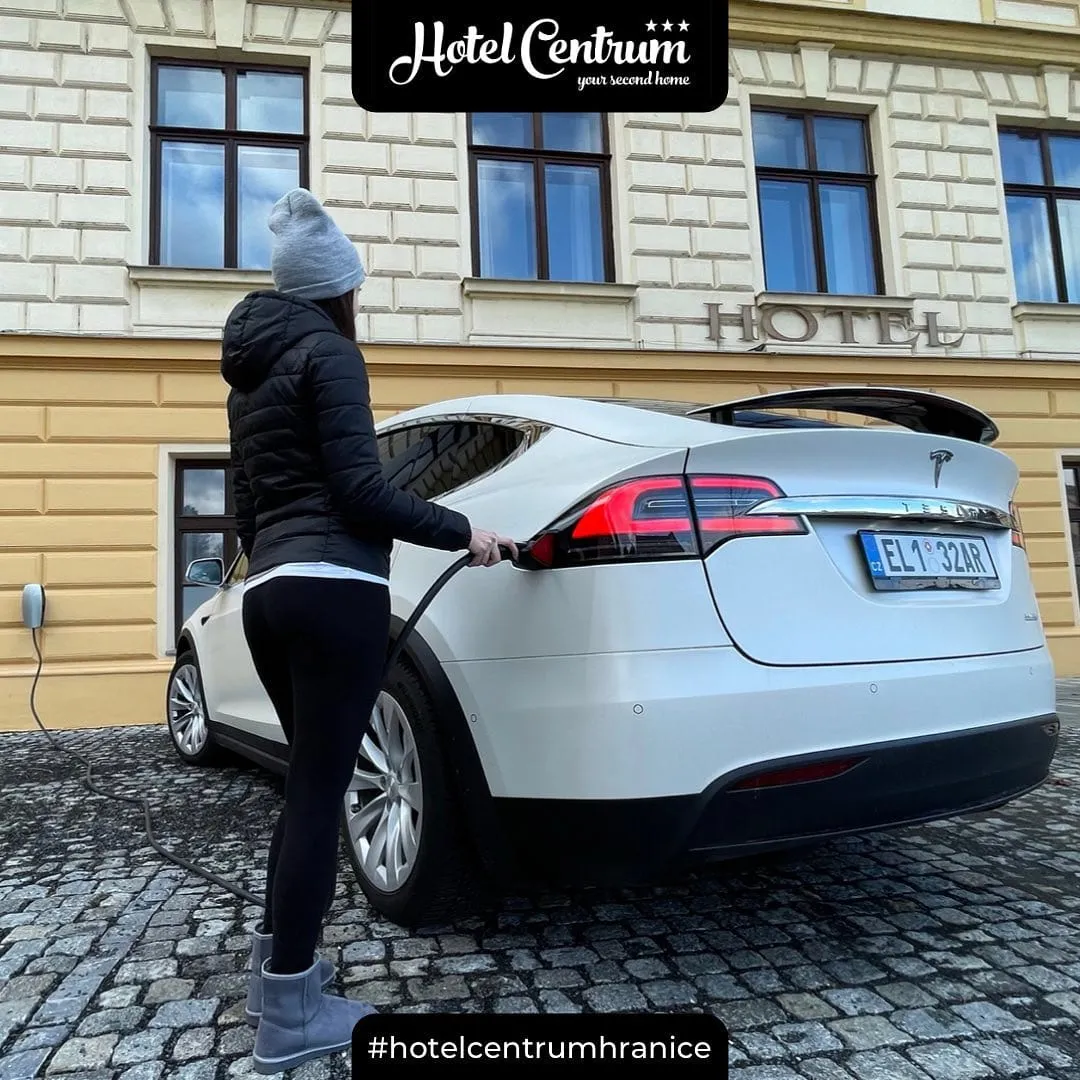Dobíjení elektromobilu Tesla před hotelem Centrum